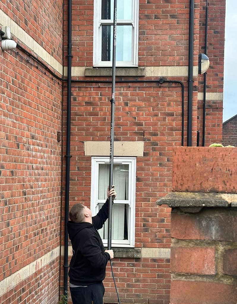 window cleaner cleaning windows on a house in Blythe Bridge Stoke-on-Trent