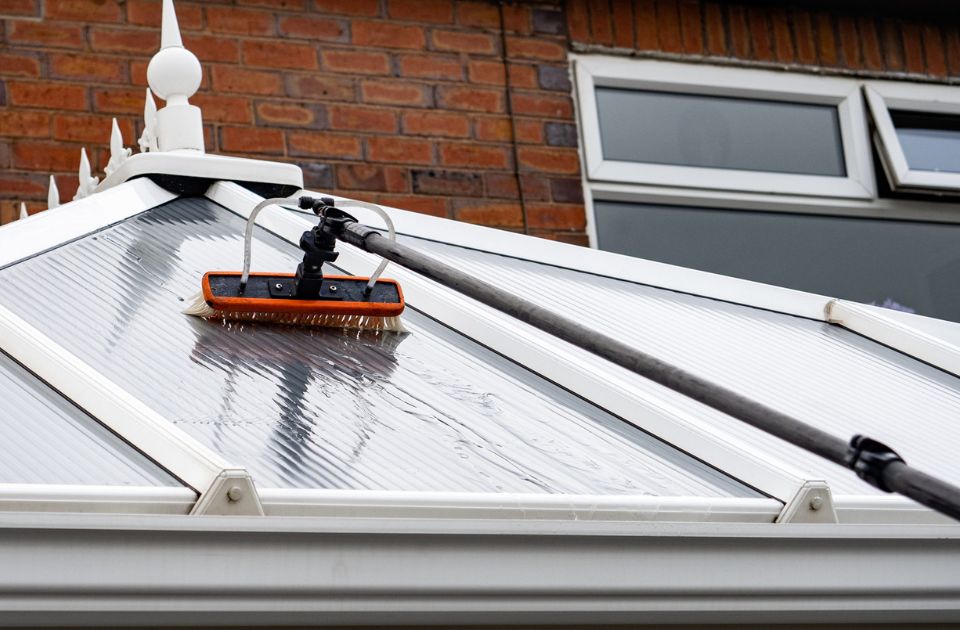 a brush cleaning a conservatory roof